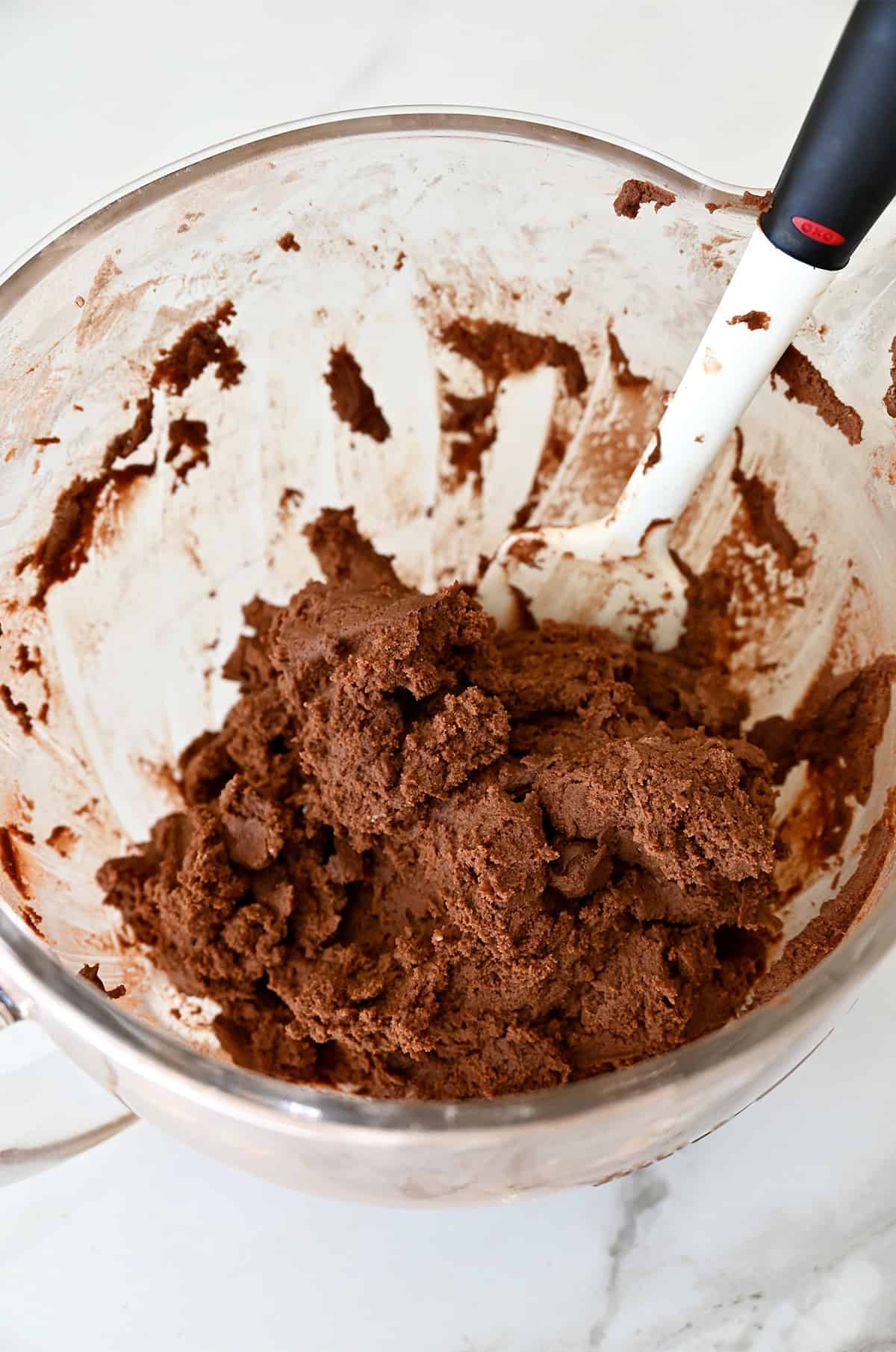 Chocolate sugar cookie dough in a stand mixer bowl.