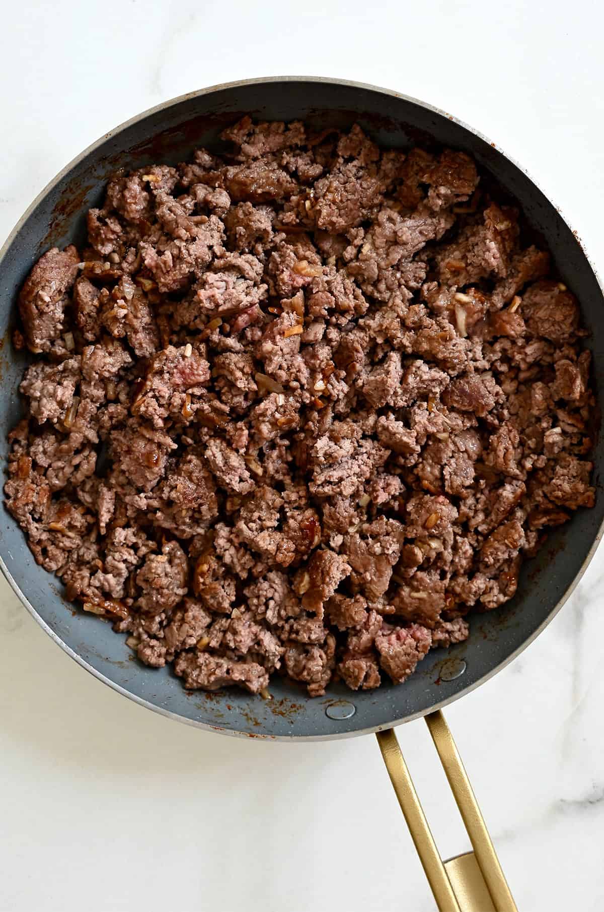 Cooked burger meat in a skillet.