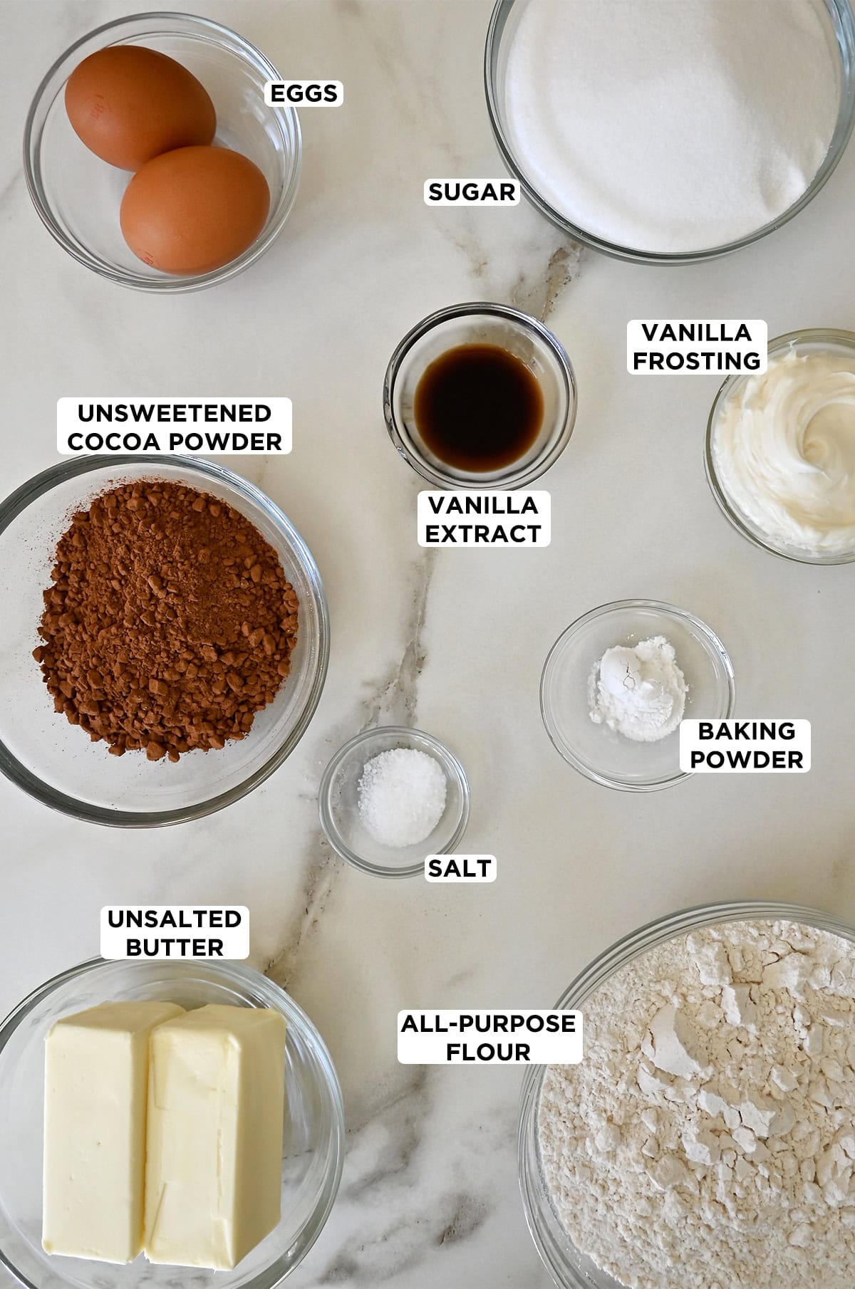 Football-shaped chocolate sugar cookie ingredients in glass bowls.