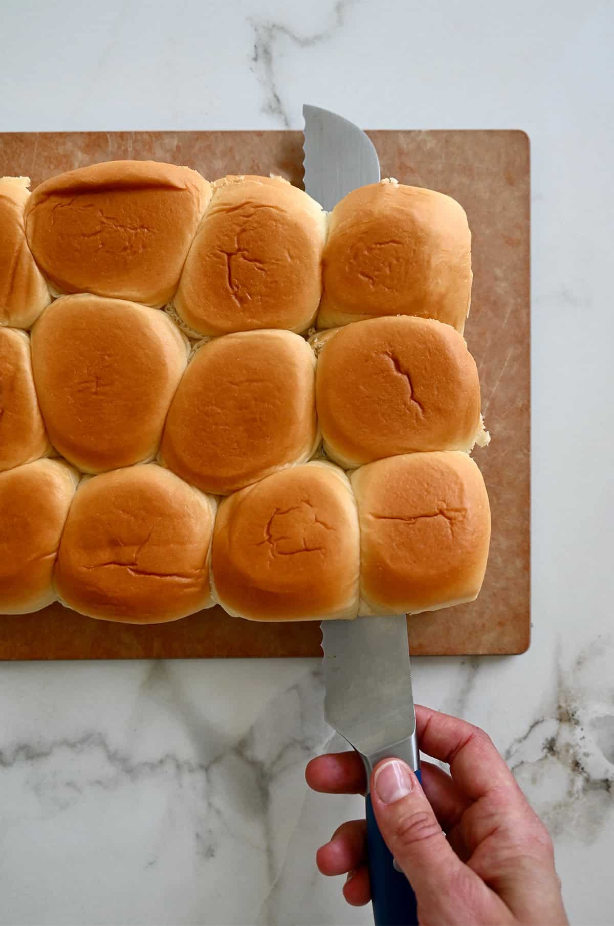 Halving slider rolls with a serrated knife.