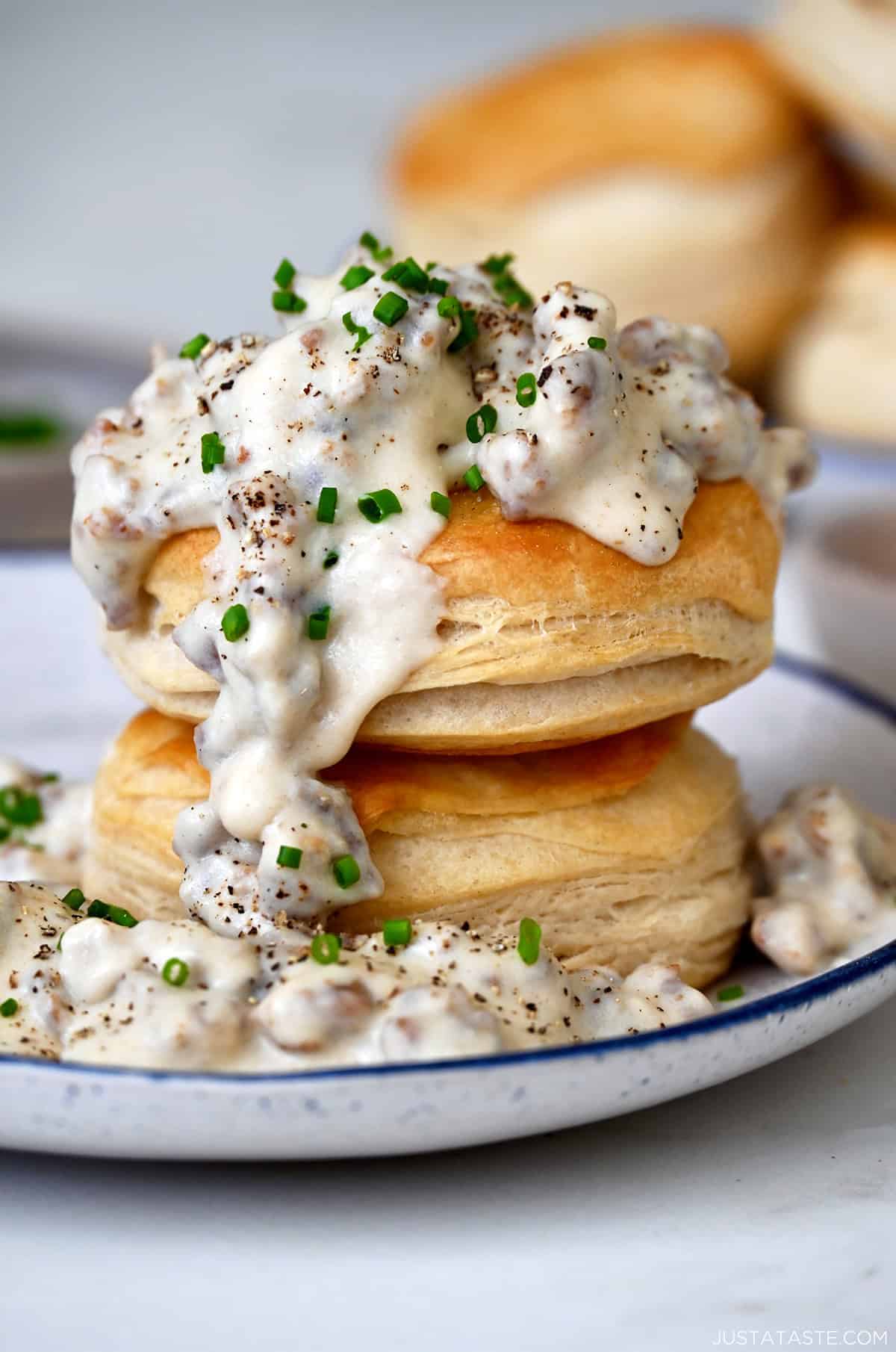 Homemade sausage gravy spooned over two flake biscuits piled atop each other.
