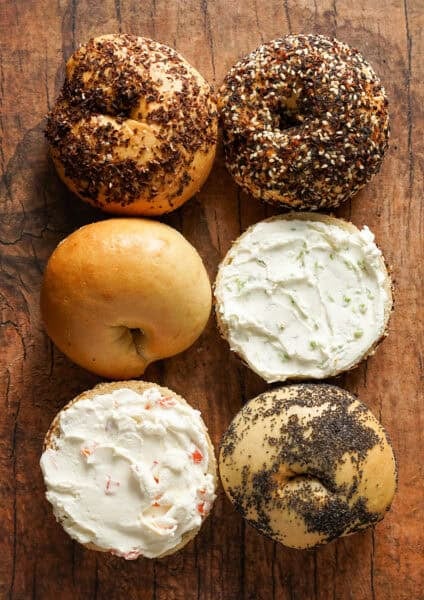 Homemade bagels slathered with two different kinds of flavored cream cheese, scallion and smoked salmon.