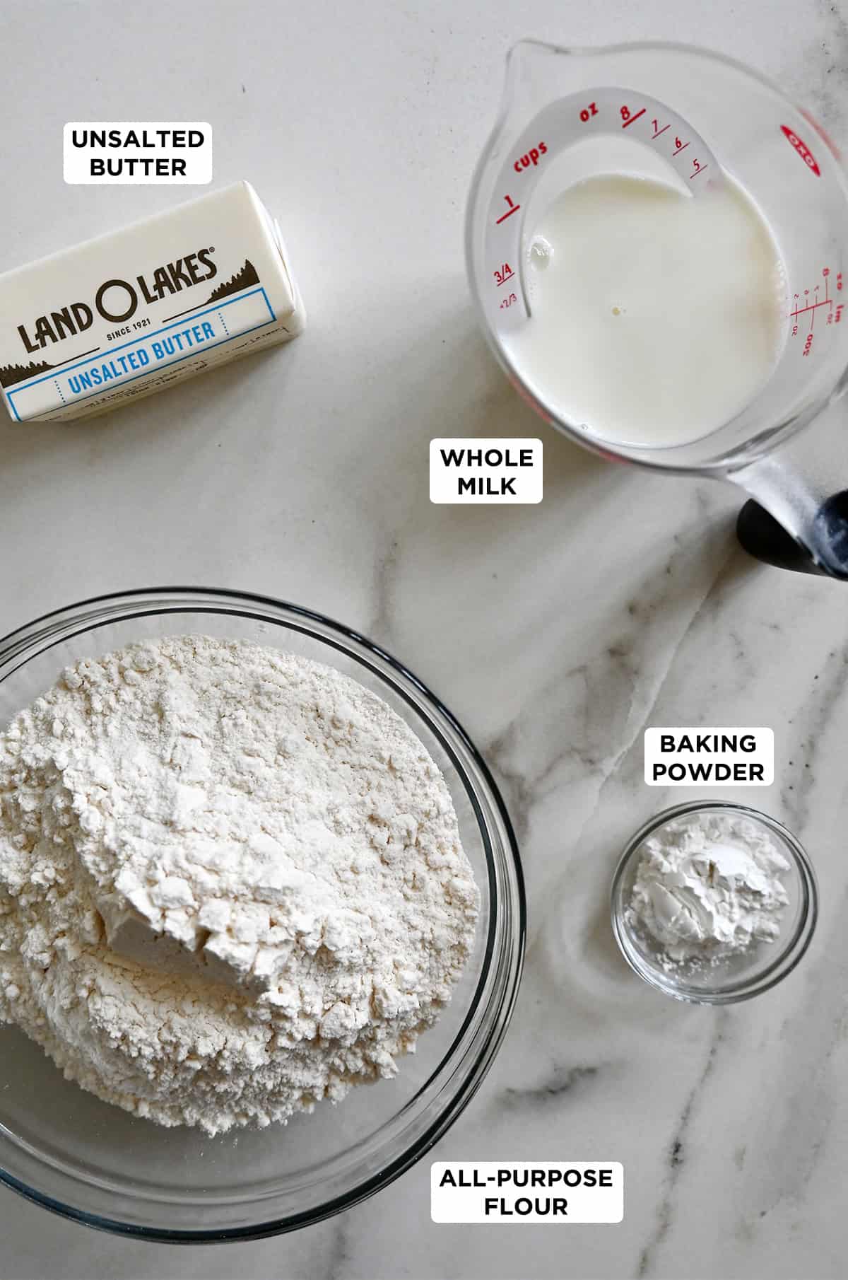 The four ingredients to make drop biscuits: all-purpose flour, baking powder, whole milk and butter.