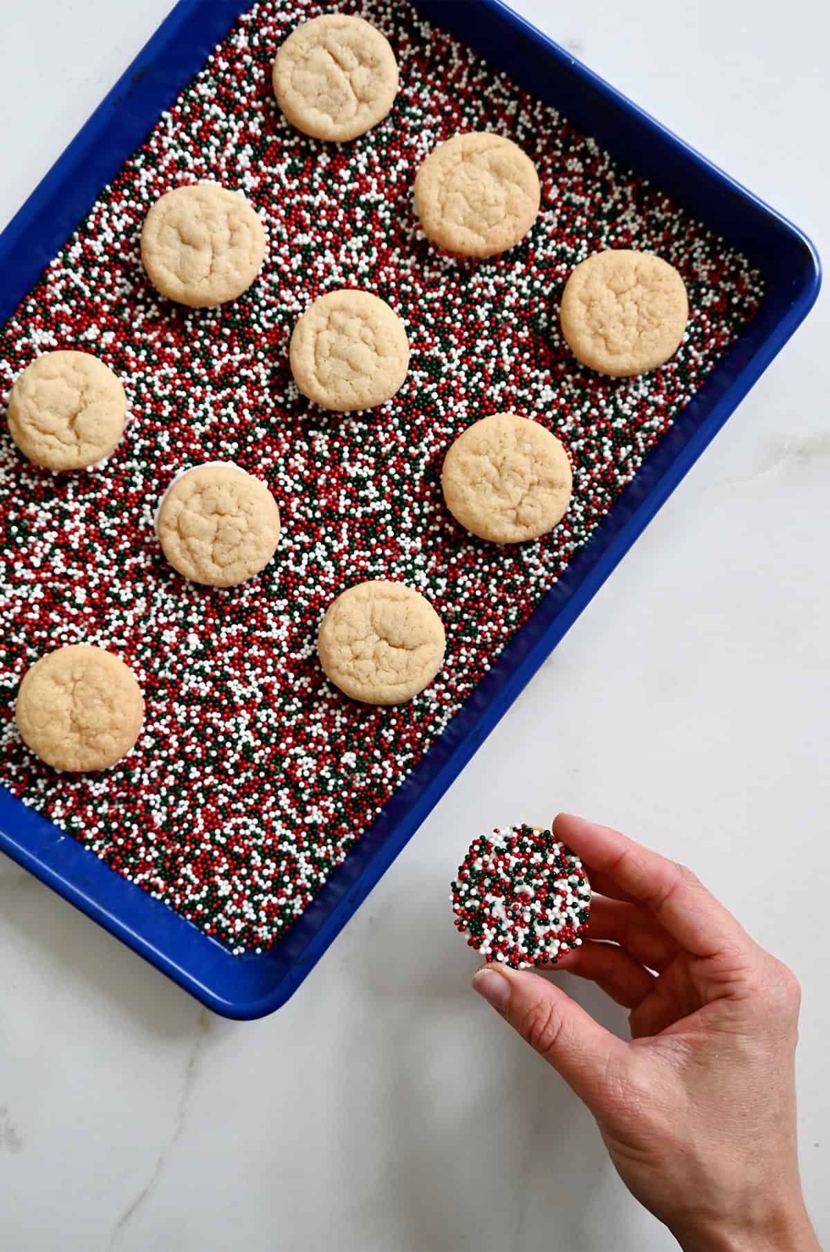 Chocolate chipless cookies dipped in white chocolate and covered in festive sprinkles.