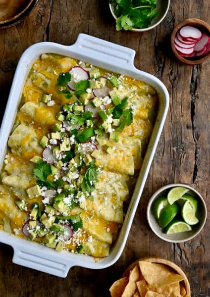 Green chili chicken enchiladas topped with diced avocado, cilantro and sliced radishes.