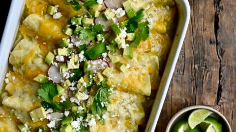 Green chili chicken enchiladas topped with diced avocado, cilantro and sliced radishes.