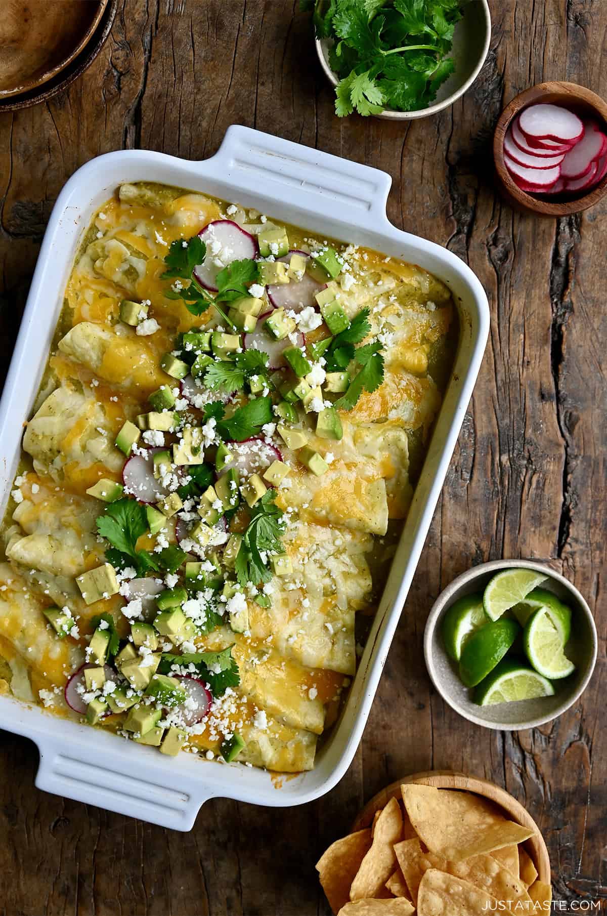 Green chili chicken enchiladas topped with diced avocado, cilantro and sliced radishes.