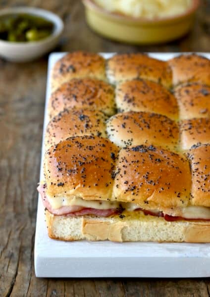 Ham and cheese sliders on Hawaiian sweet rolls topped with a poppy seed butter sauce.