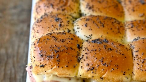Ham and cheese sliders on Hawaiian sweet rolls topped with a poppy seed butter sauce.