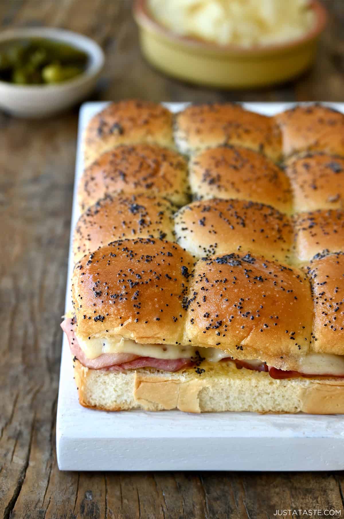 Ham and cheese sliders on Hawaiian sweet rolls topped with a poppy seed butter sauce.