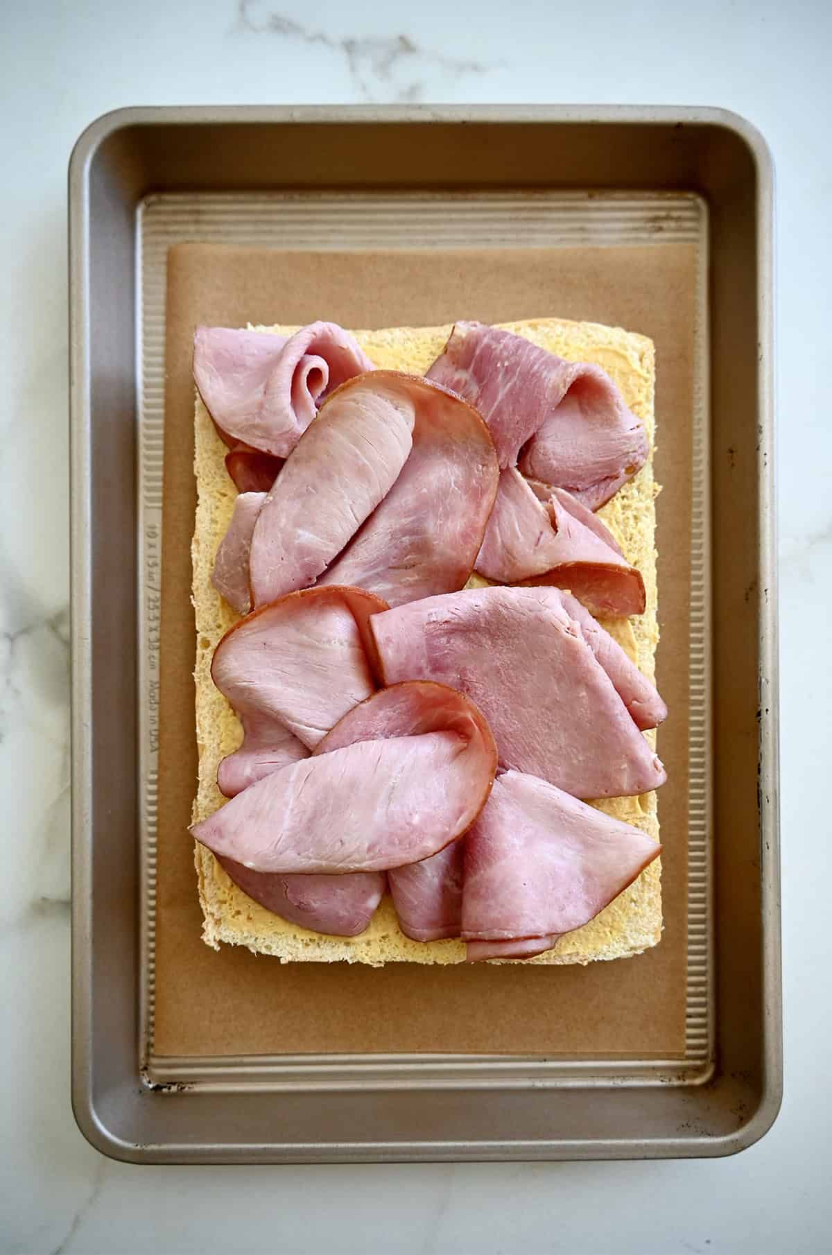 Slices of ham piled atop halved sweet rolls slathered with Dijon mustard.