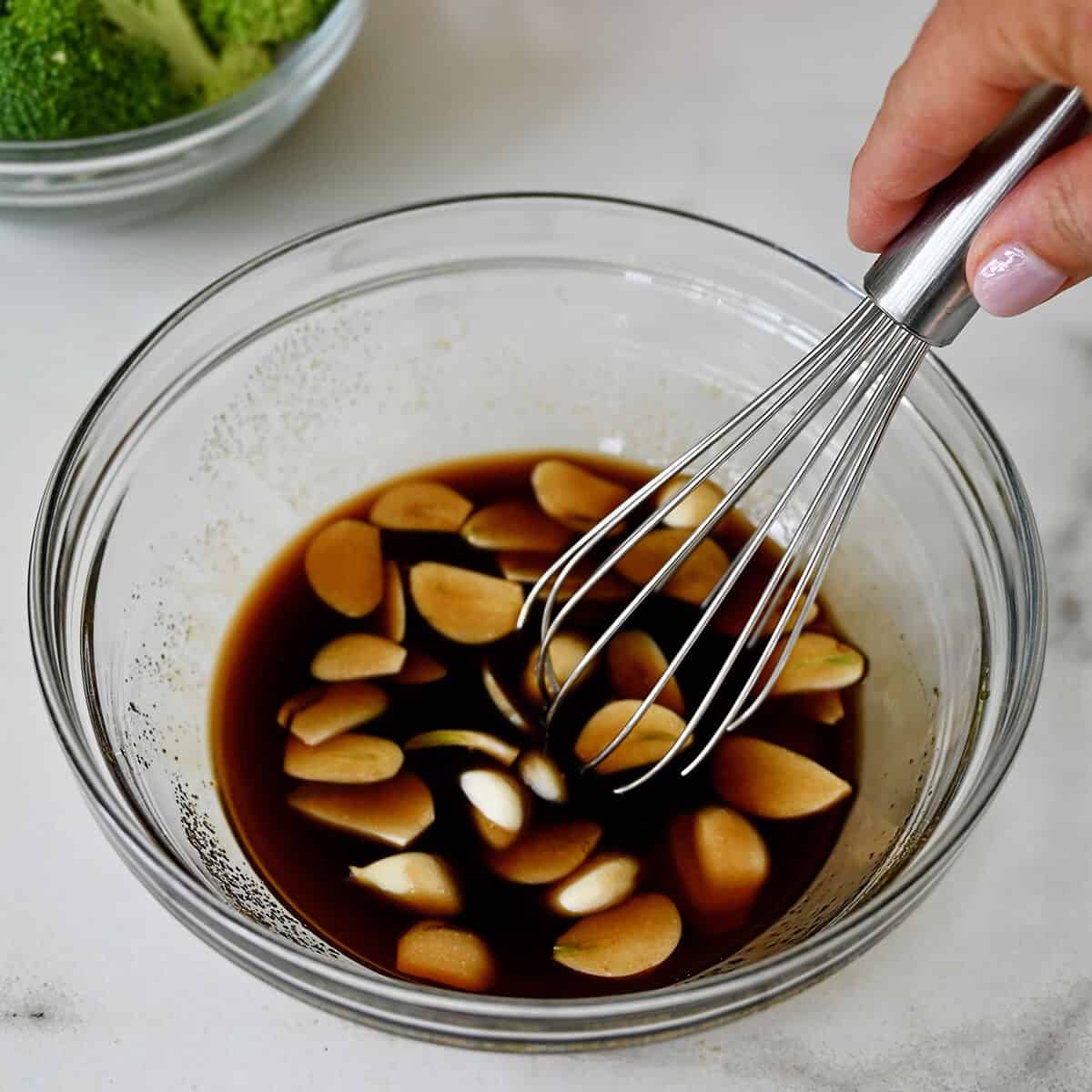 Drunken noodles sauce in a small bowl with a whisk.