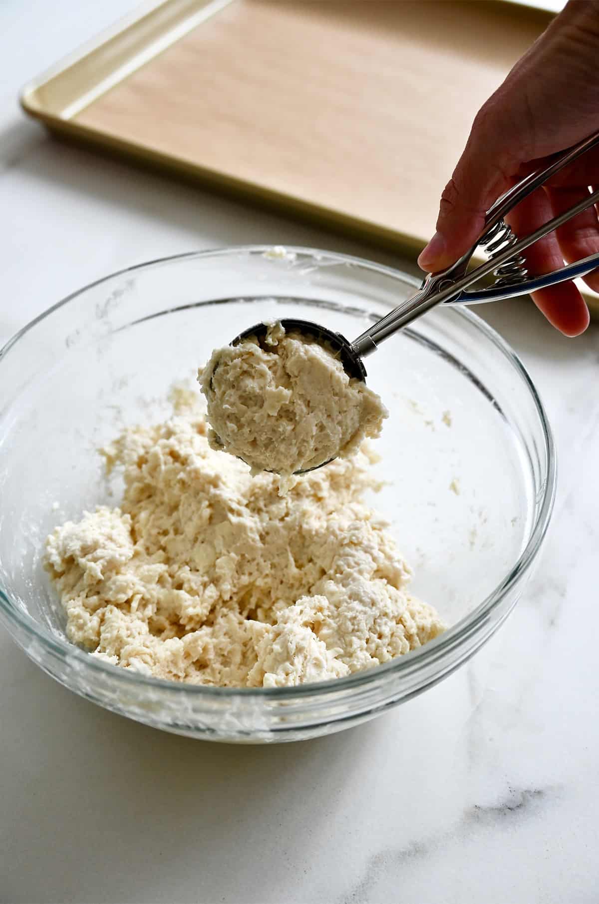 Scooping drop biscuit dough with a small cookie scoop.