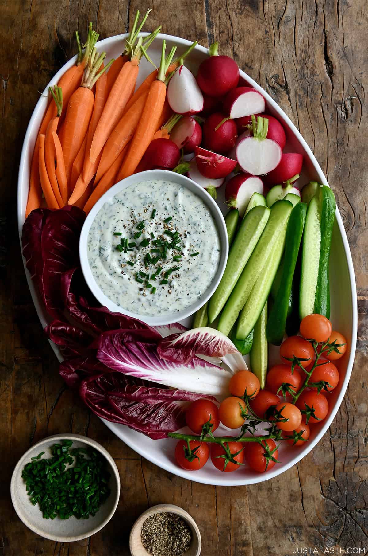 Whipped cottage cheese dip in a small bowl on a platter surrounded by fresh veggies.