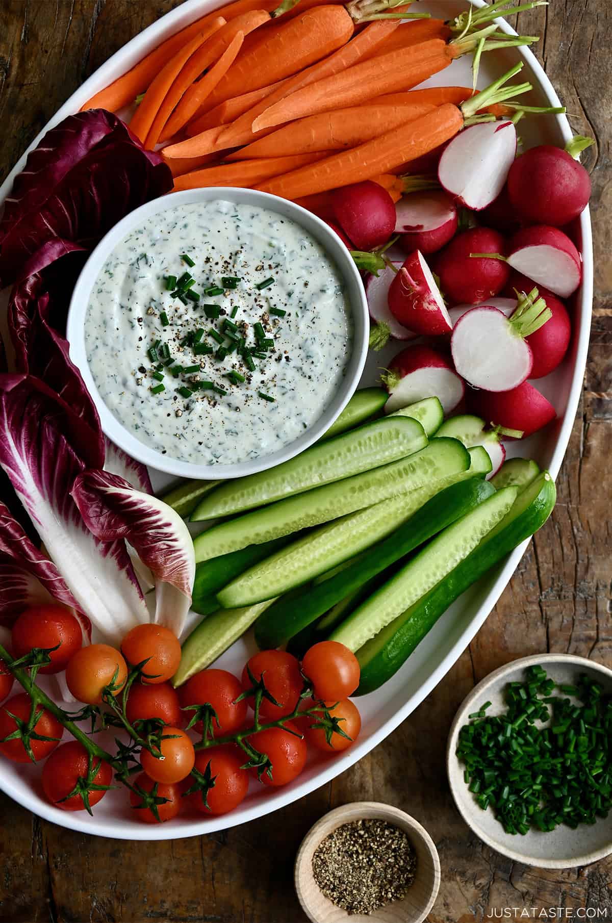 High protein cottage cheese veggie dip in a small bowl on a serving platter surrounded by fresh veggies.