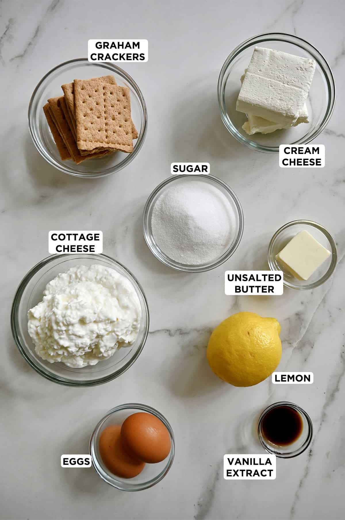 Ingredients to make cottage cheese cheesecake in various sizes of glass bowls.