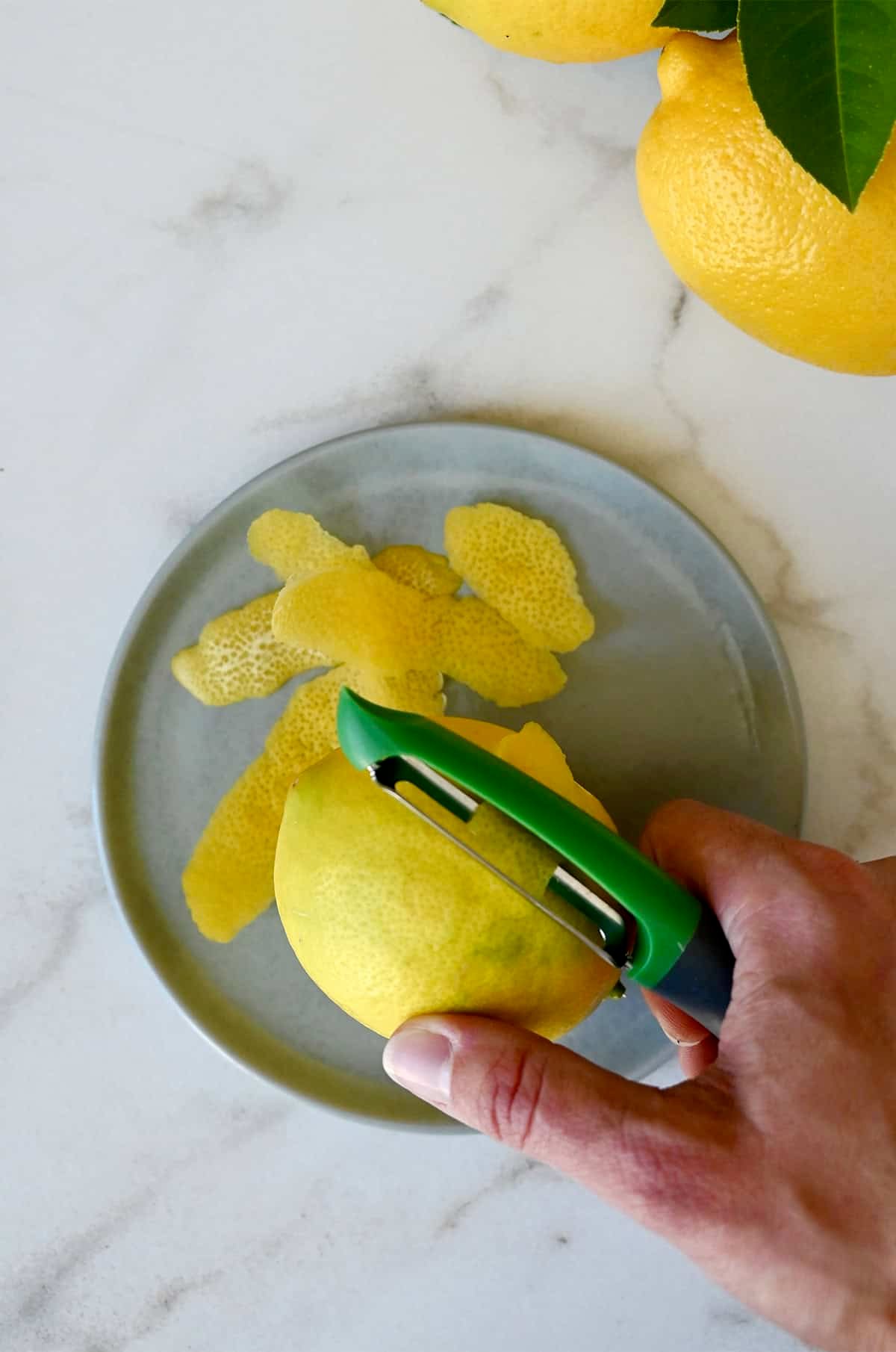 How to zest a lemon using a vegetable peeler.