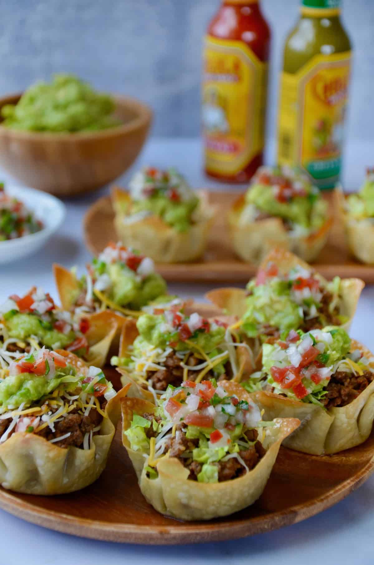 Taco salad cups in wonton wrappers on a serving platter.