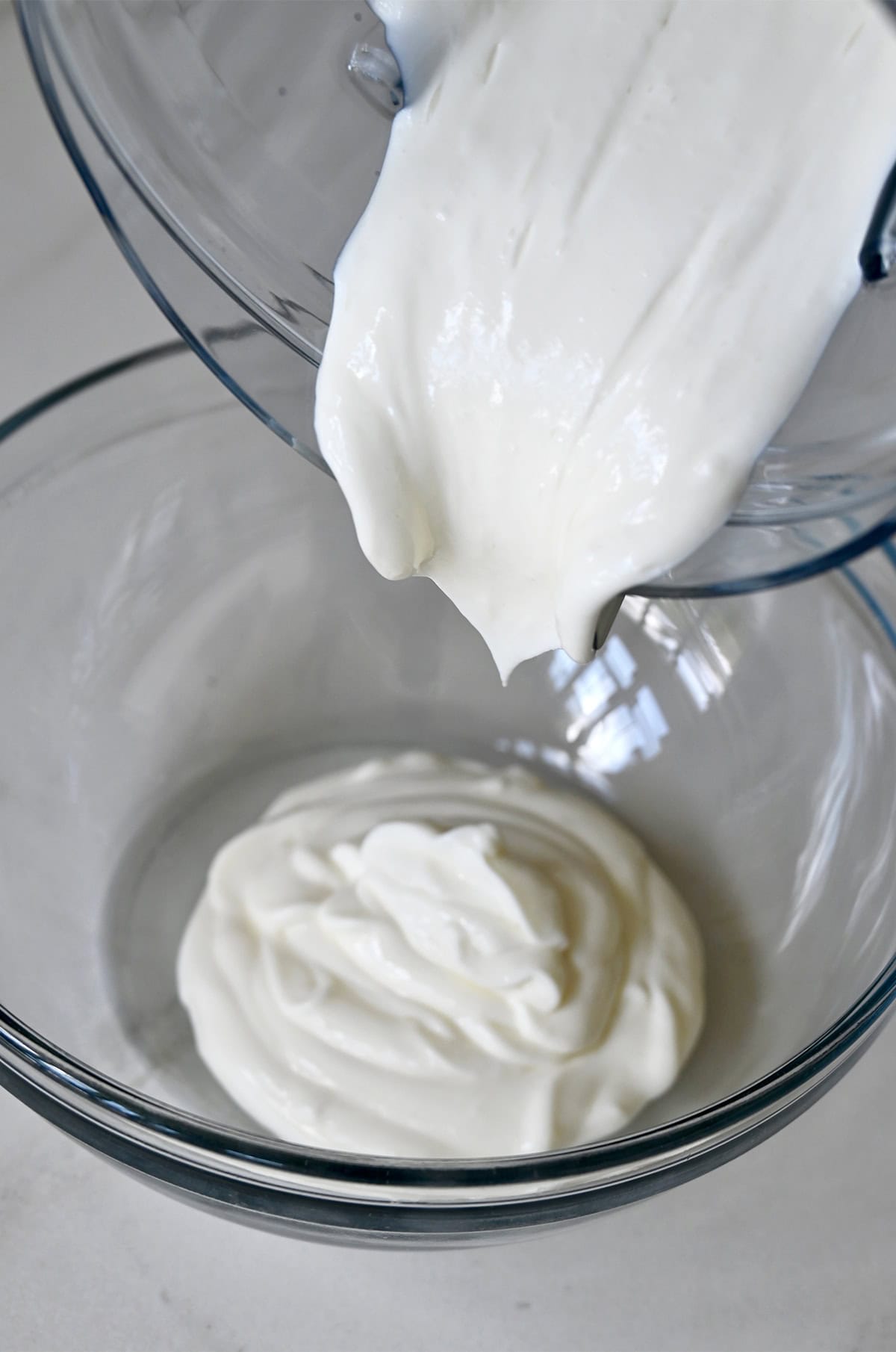 Blended cottage cheese being poured from a blender into a bowl.