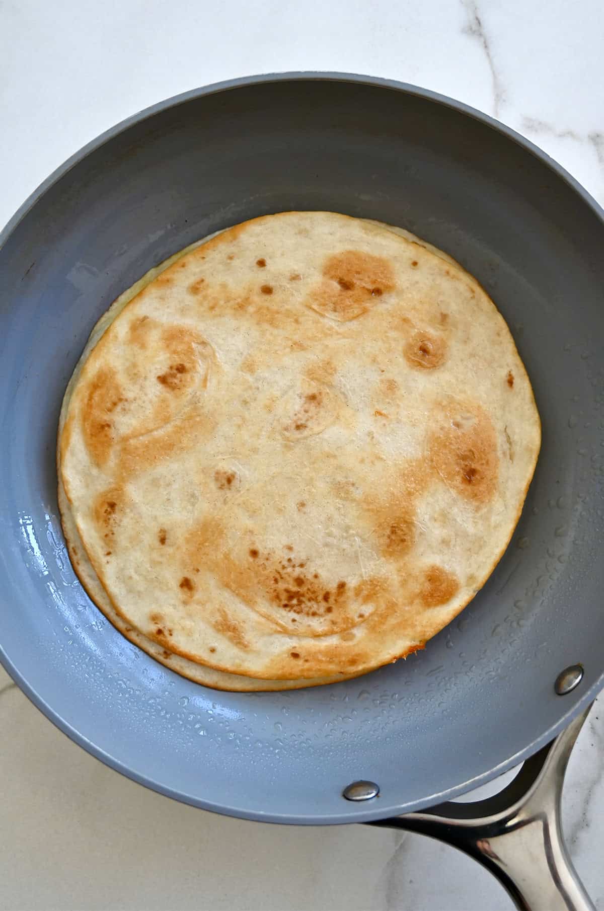 A two-tortilla cheese quesadilla in a skillet.