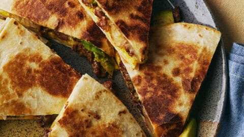 Homemade quesadilla cut into five triangles on a plate.