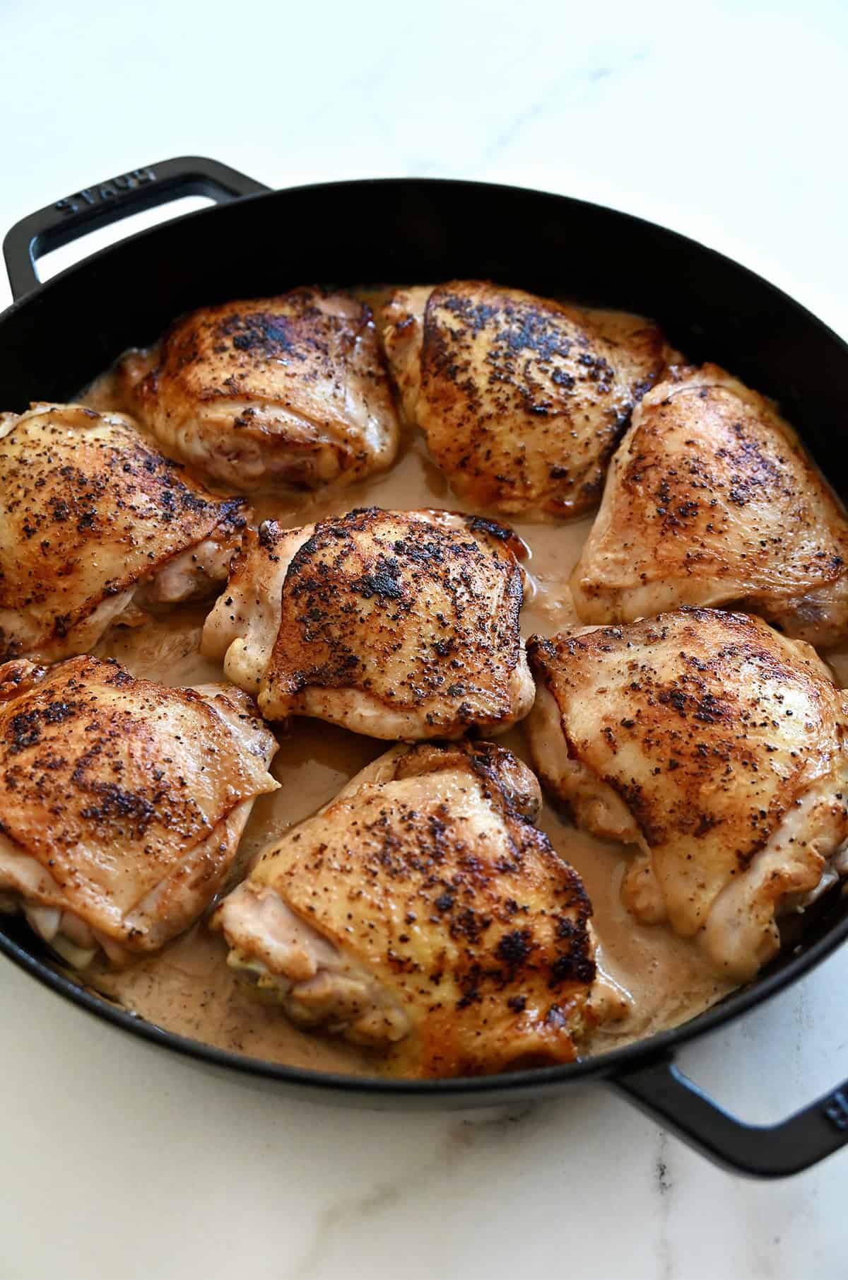 Browned chicken thighs in homemade lemon pepper sauce.