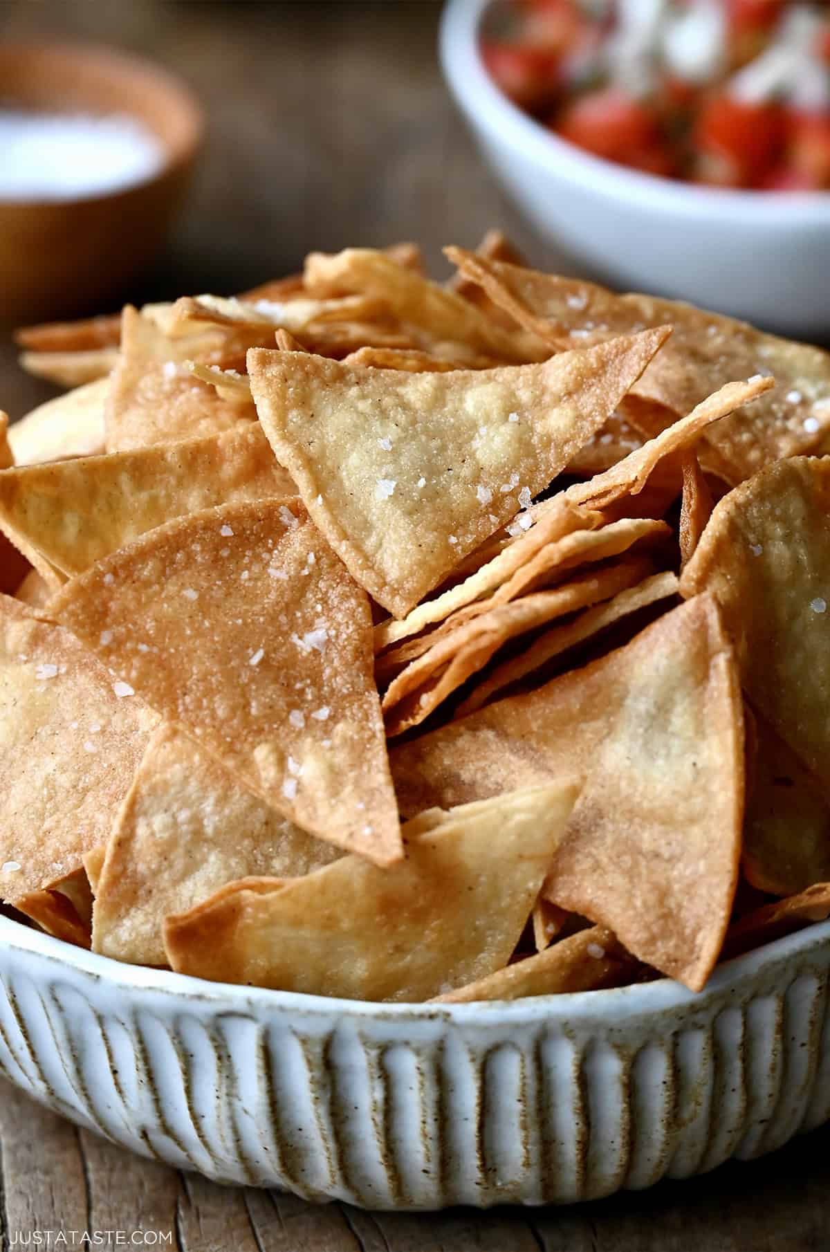 A big bowl overflowing with crispy, salty homemade tortilla chips.