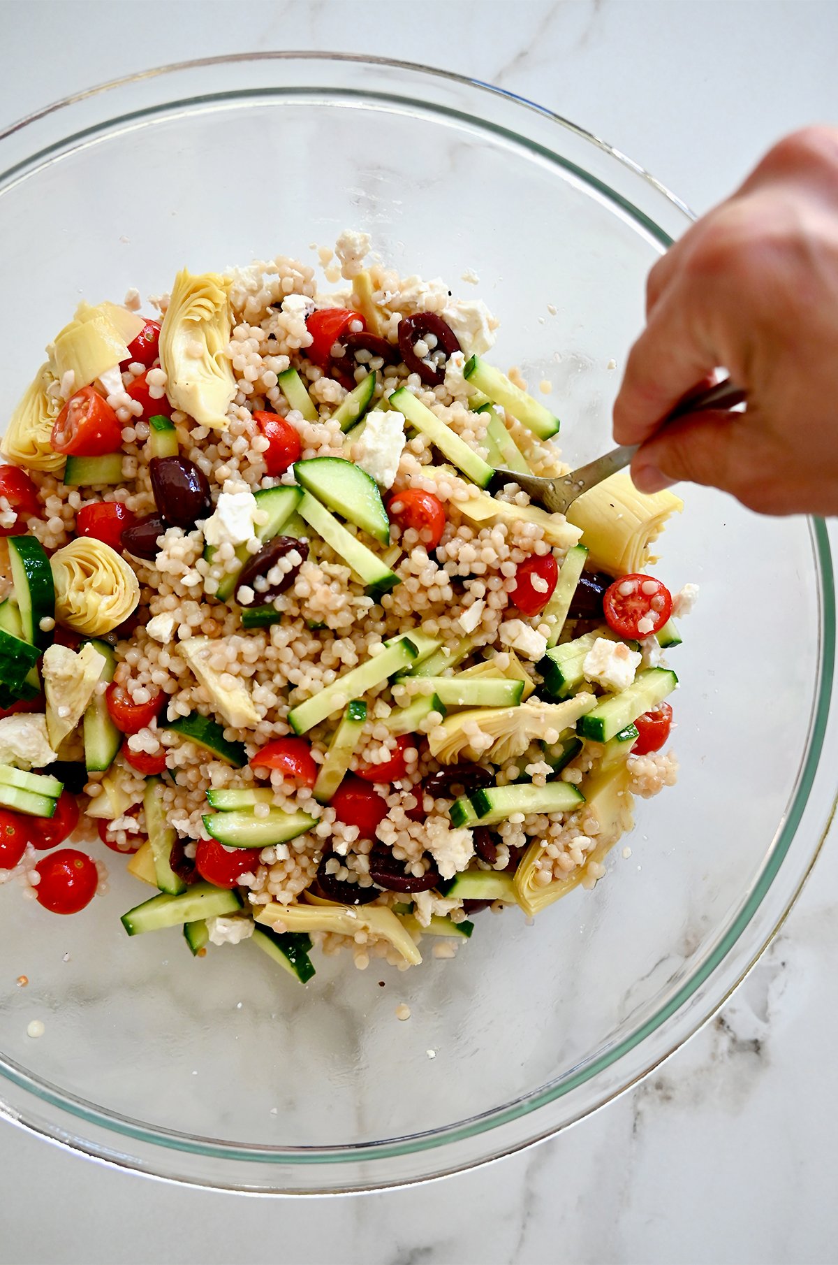 Tossing couscous salad with a red wine vinaigrette. 
