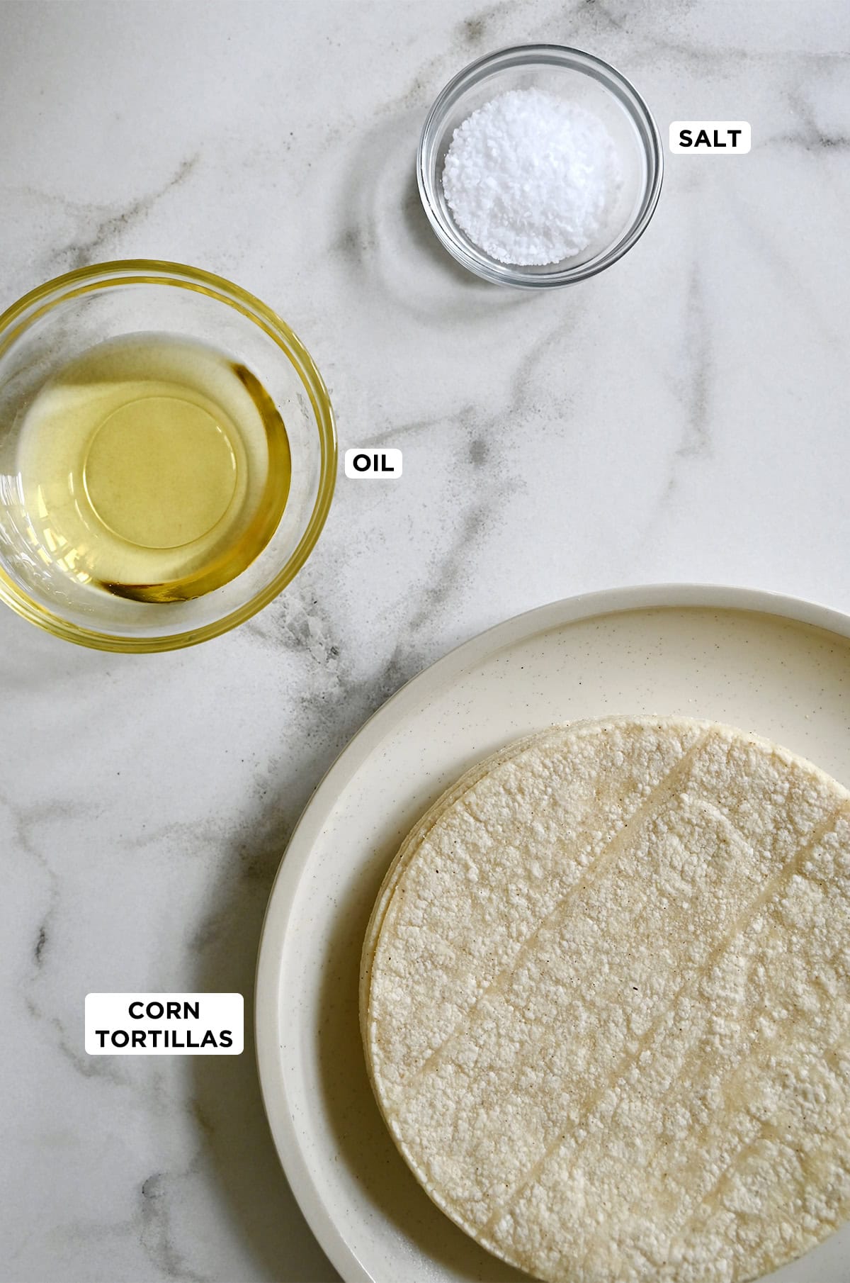 Ingredients to make homemade tortilla chips: corn tortillas, oil and salt.