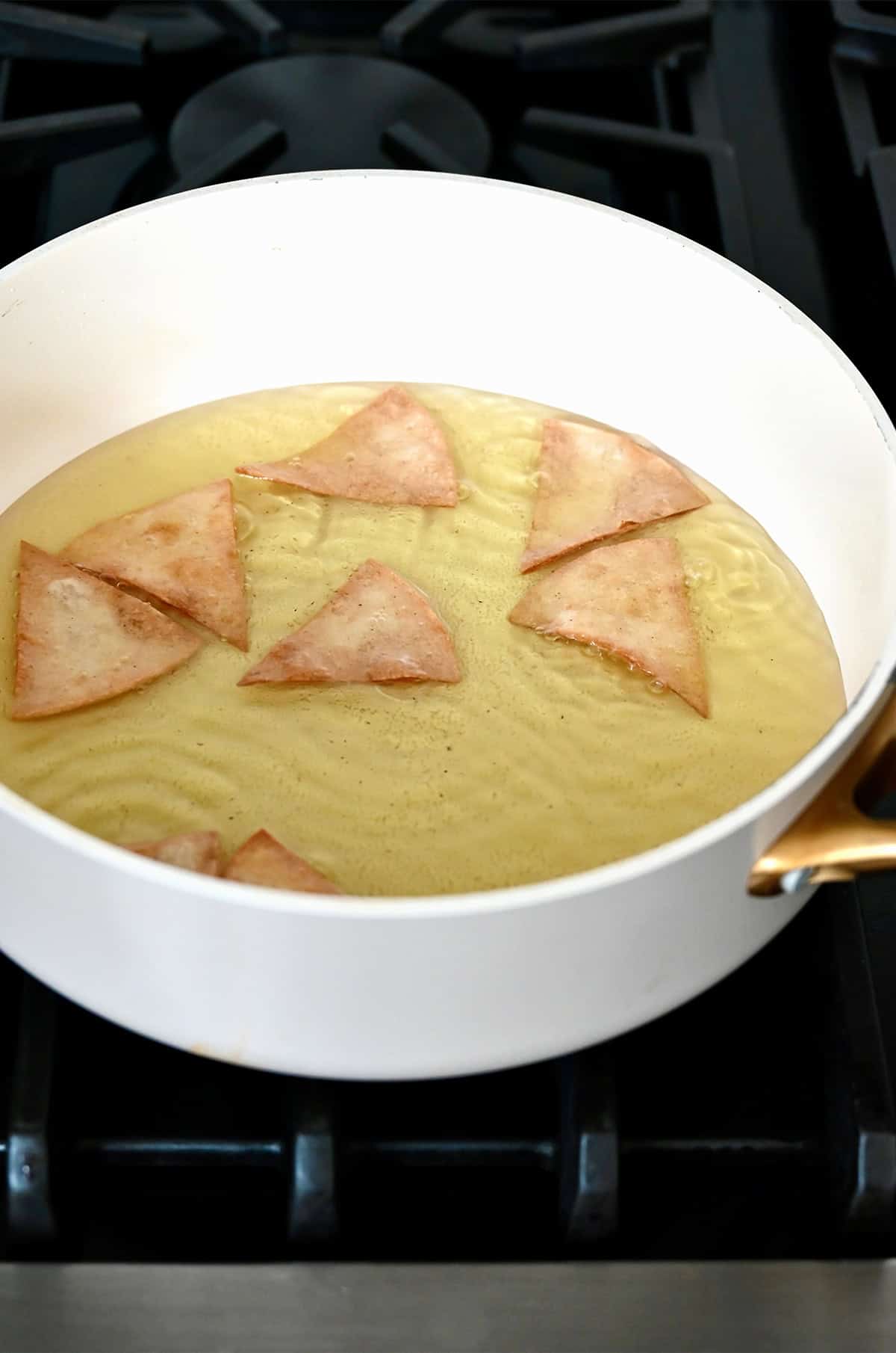 Frying tortilla chips in hot oil.