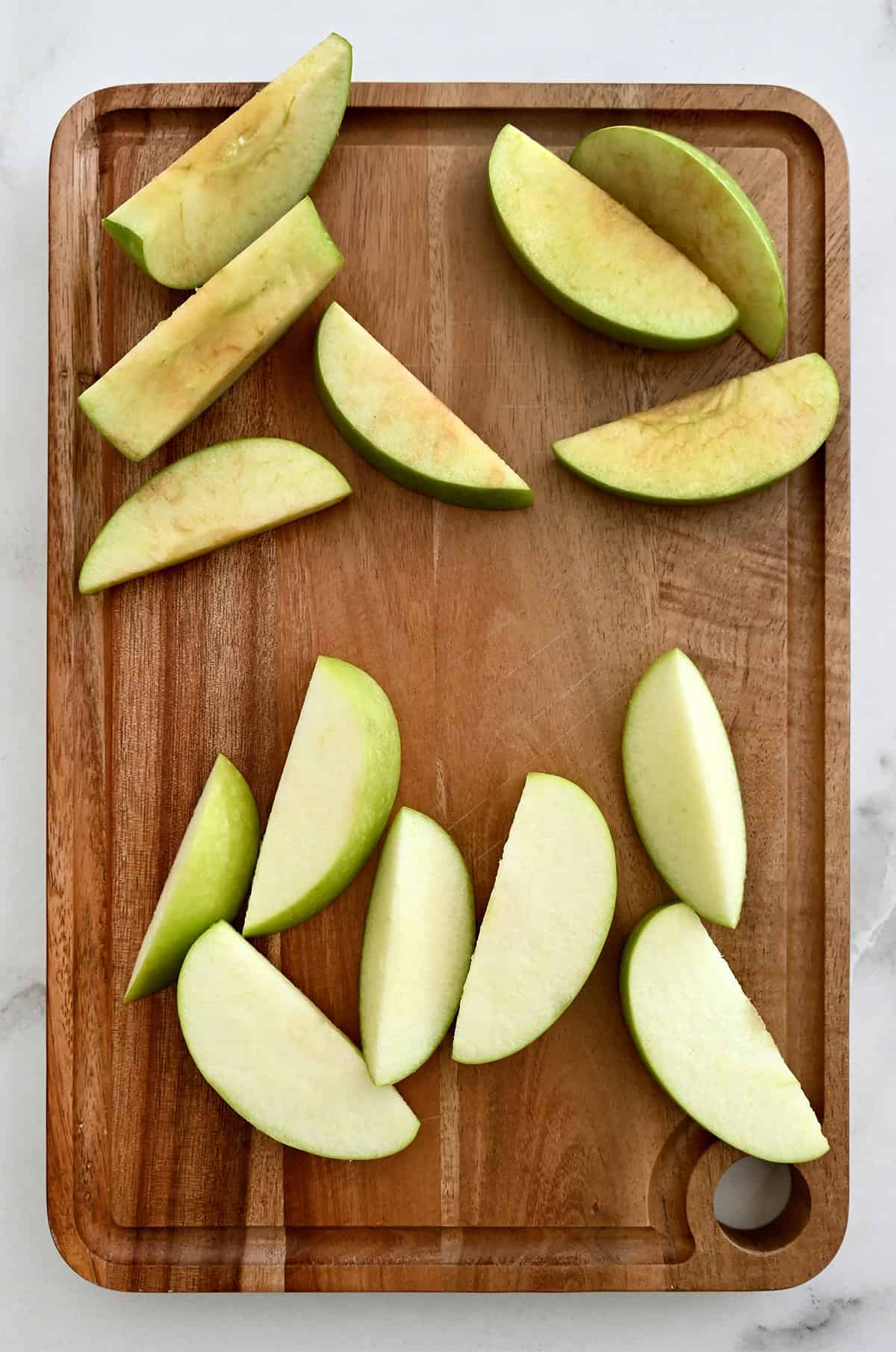 Apple slices that have turned brown next to apple slices that have been soaked in water and haven't turned brown.
