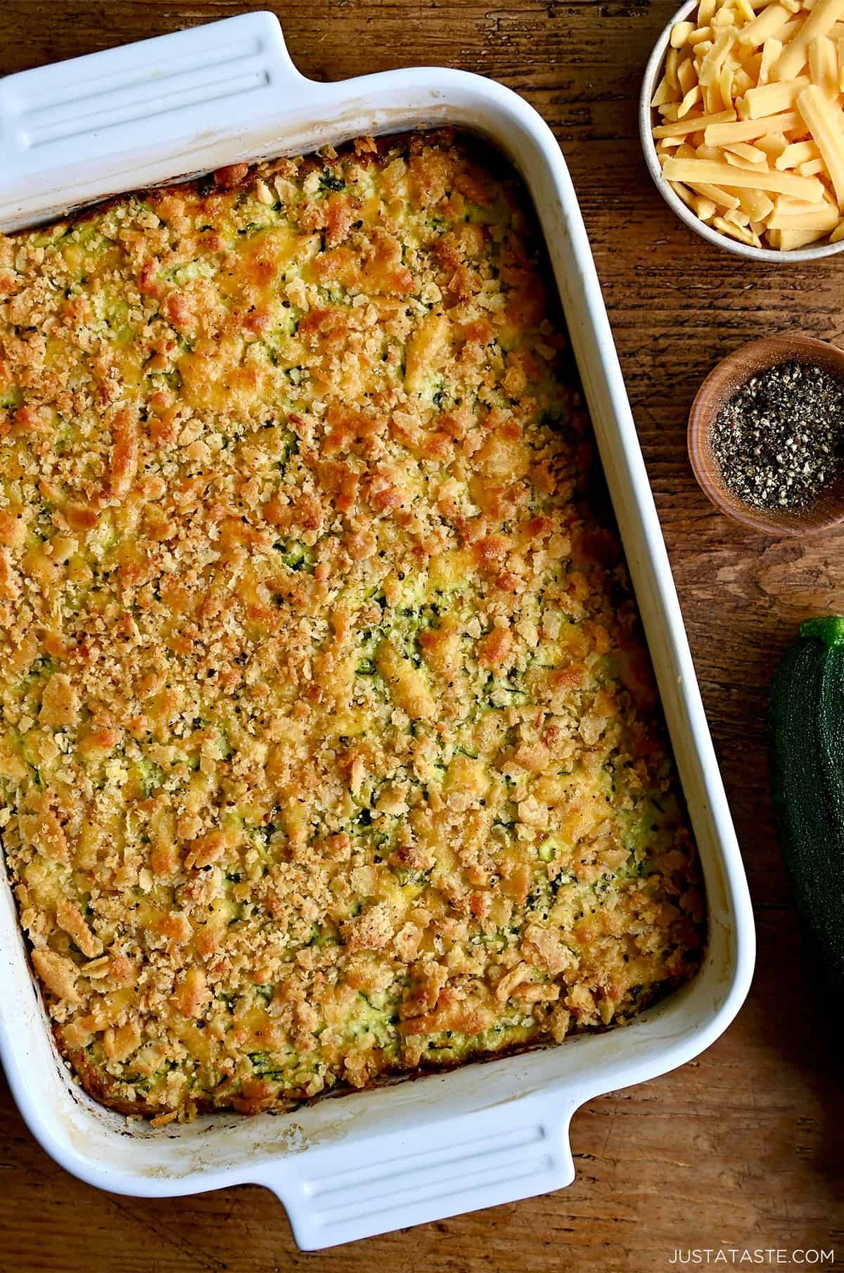 A shredded zucchini casserole with a cracker topping in a white baking dish.