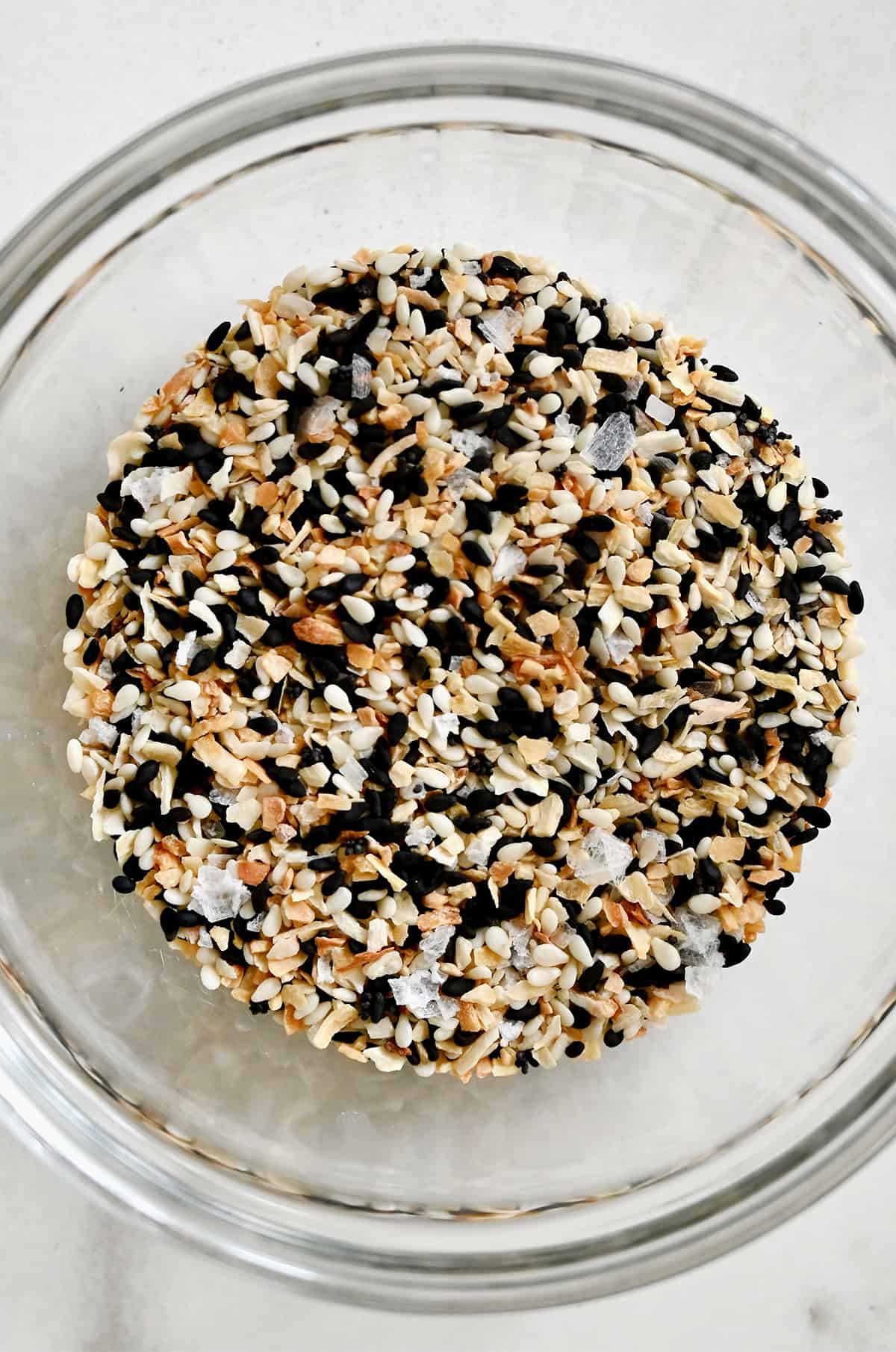 A homemade mix of everything bagel seasoning in a glass bowl.