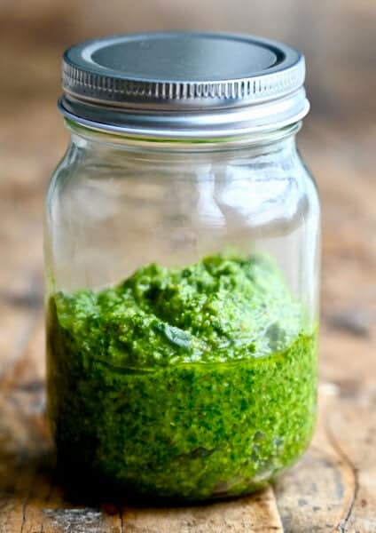 Homemade basil pesto in a mason jar.