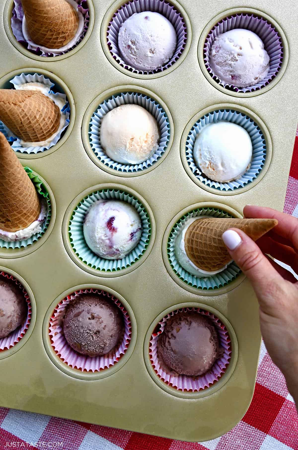 Pre-scooped ice cream in a muffin tin lined with cupcake liners.