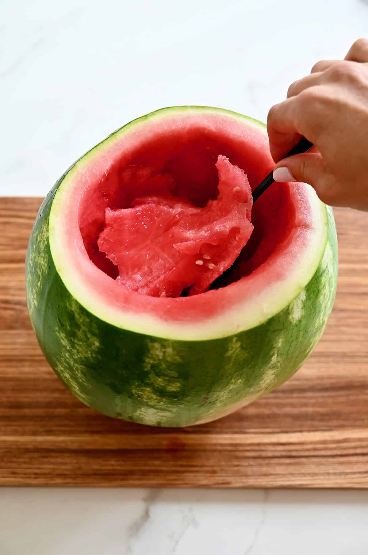Scooping out the center of a watermelon.