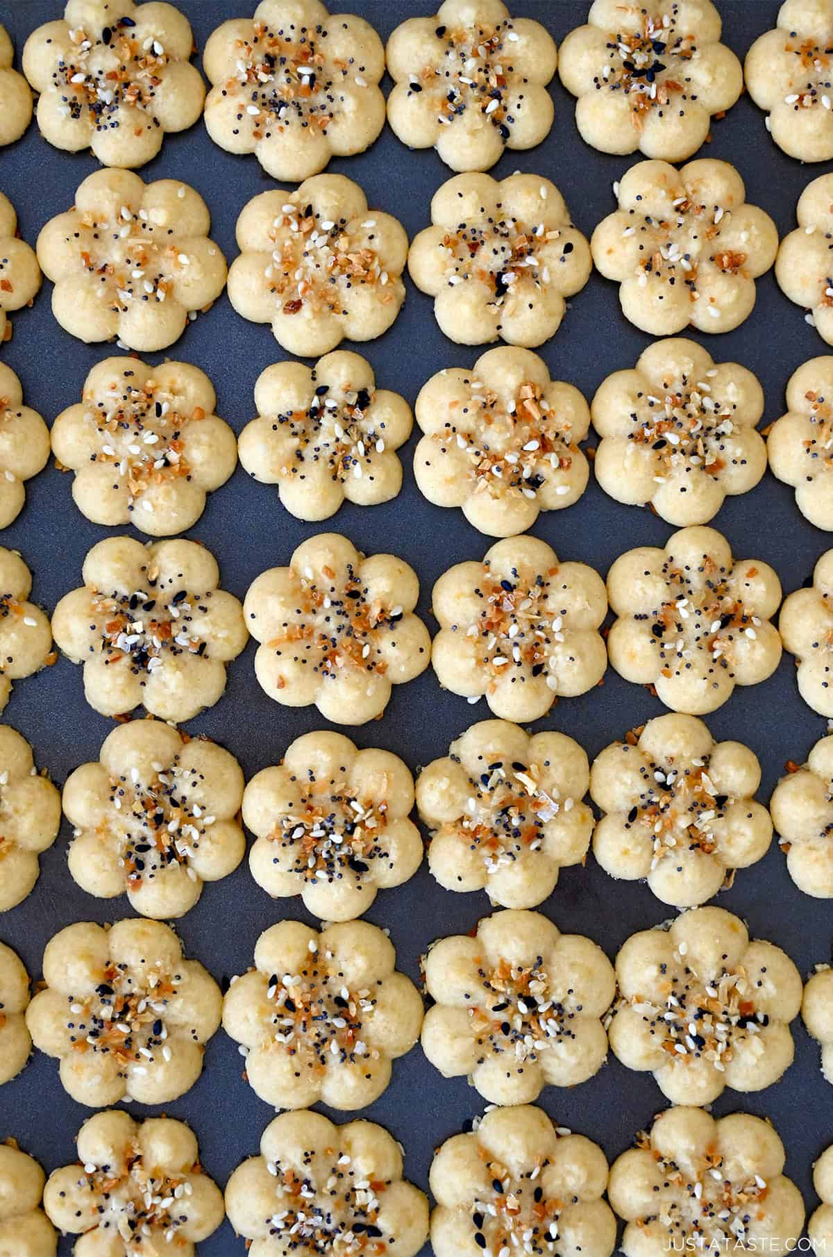 Golden Southern cheese crackers (savory spritz cookies) pressed into flower shapes and sprinkled with everything seasoning.