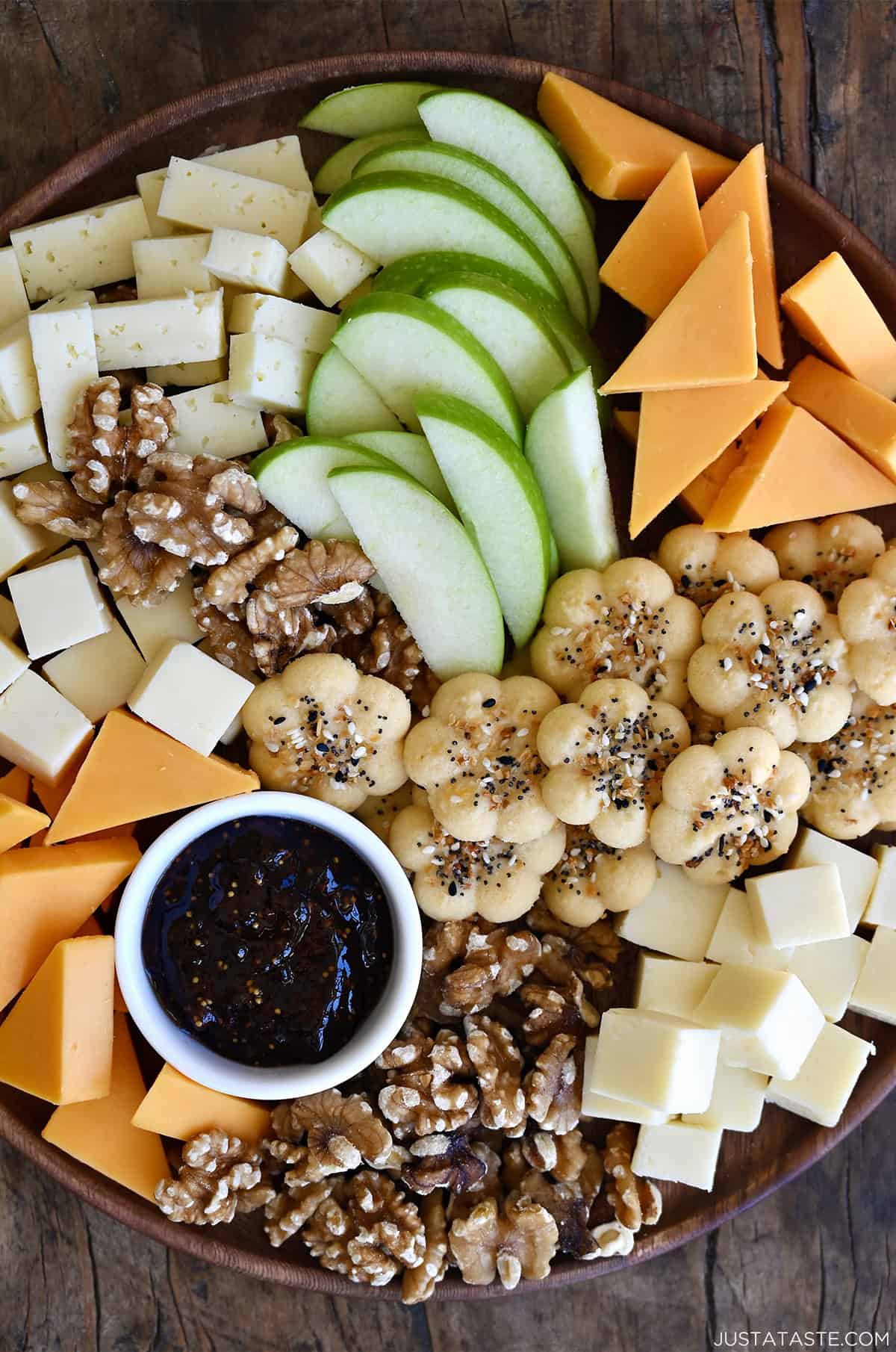 Golden Southern Cheese Crackers (savory spritz cookies) pressed into festive shapes and sprinkled with everything seasoning, arranged on a charcuterie board for cocktail hour.
