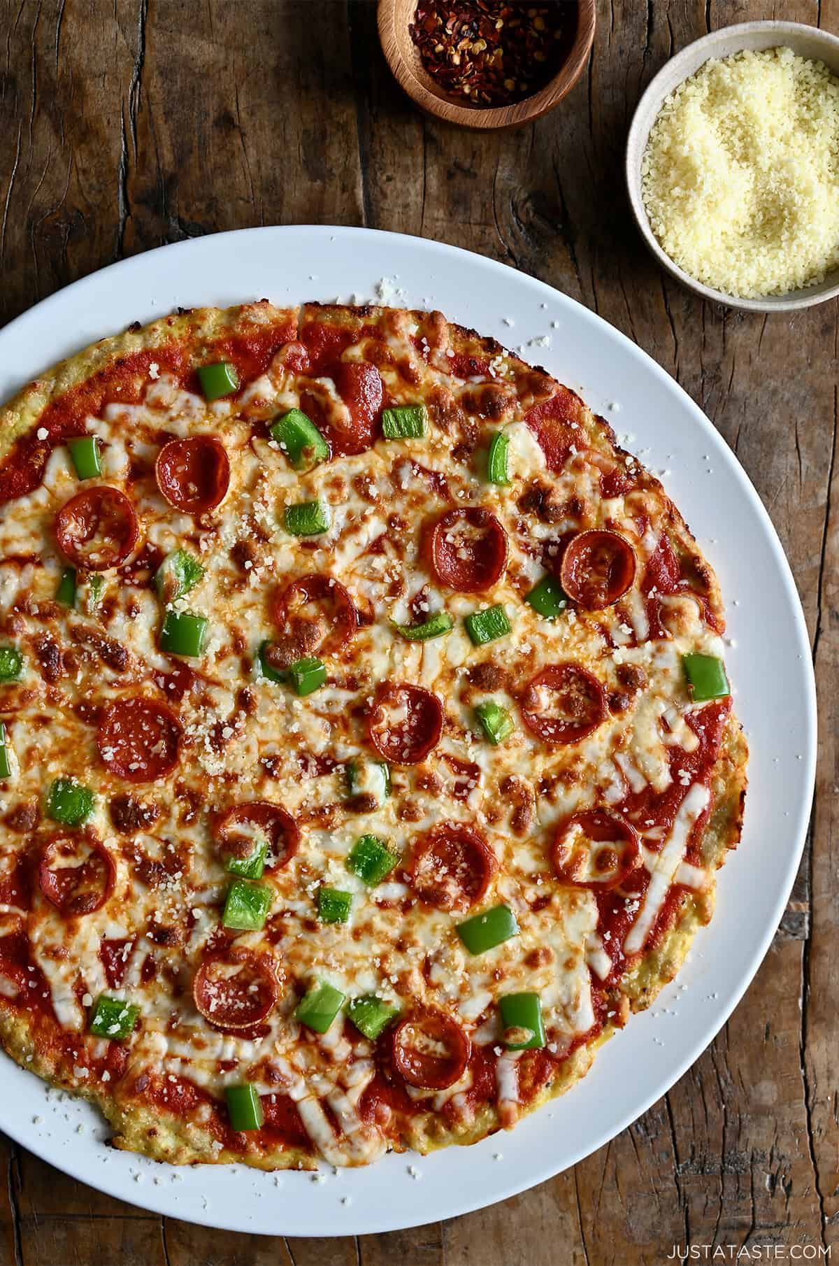 Golden brown low-carb chicken crust pizza topped with melted cheese, pepperoni and diced green peppers.