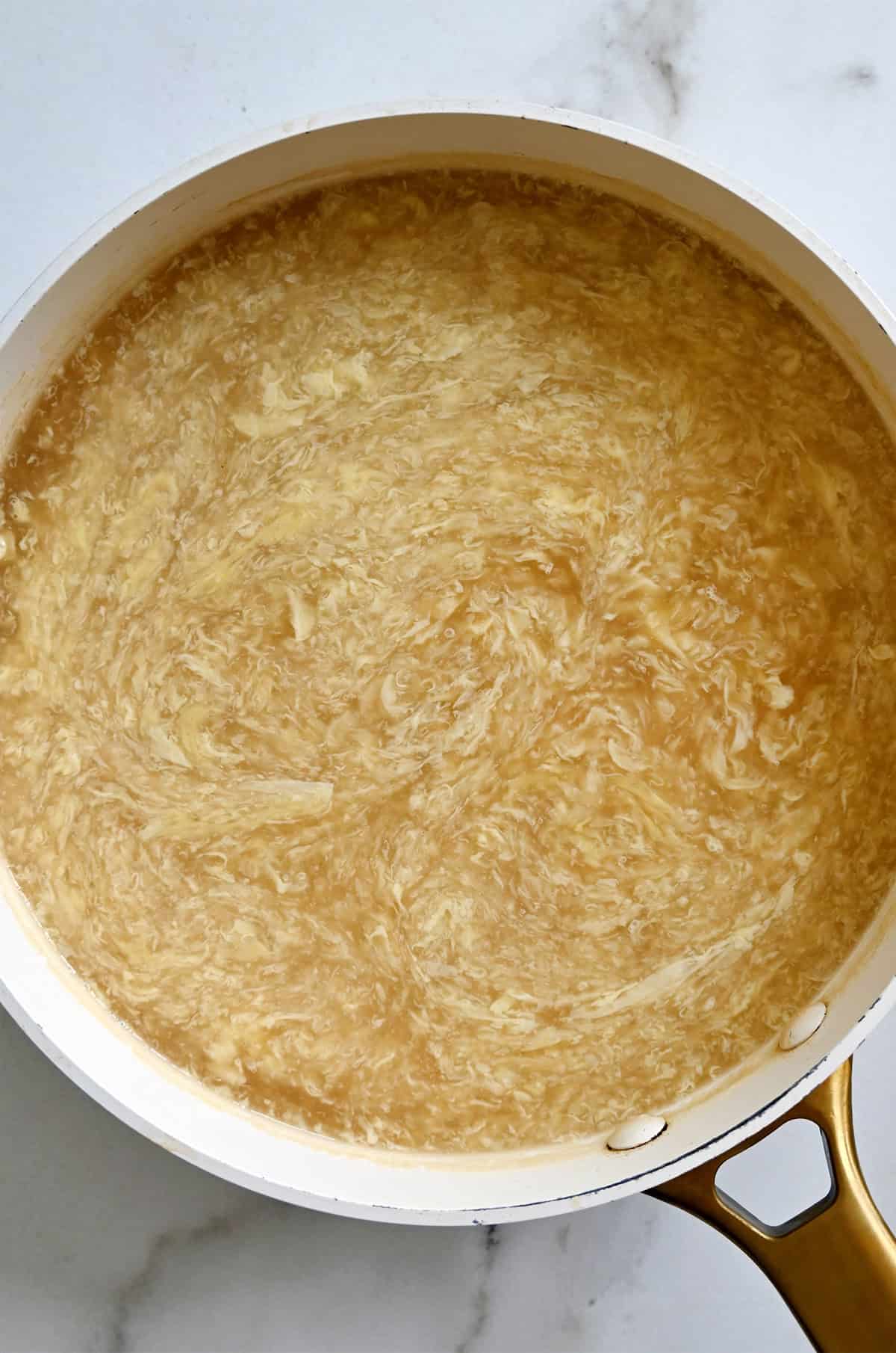 Homemade egg drop soup in a stock pot.
