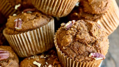 A bowl overflowing with healthy pumpkin muffins studded with pecans.