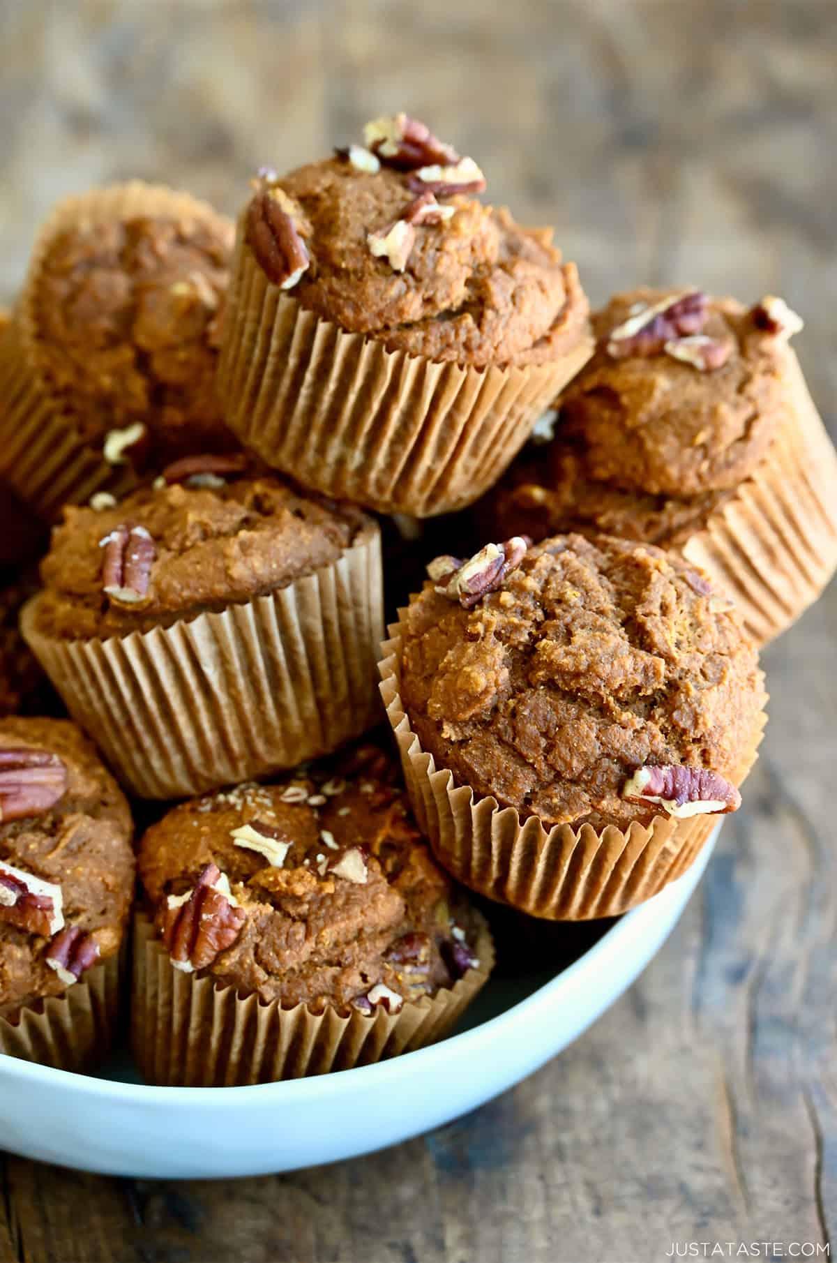 A bowl overflowing with healthy pumpkin muffins studded with pecans.