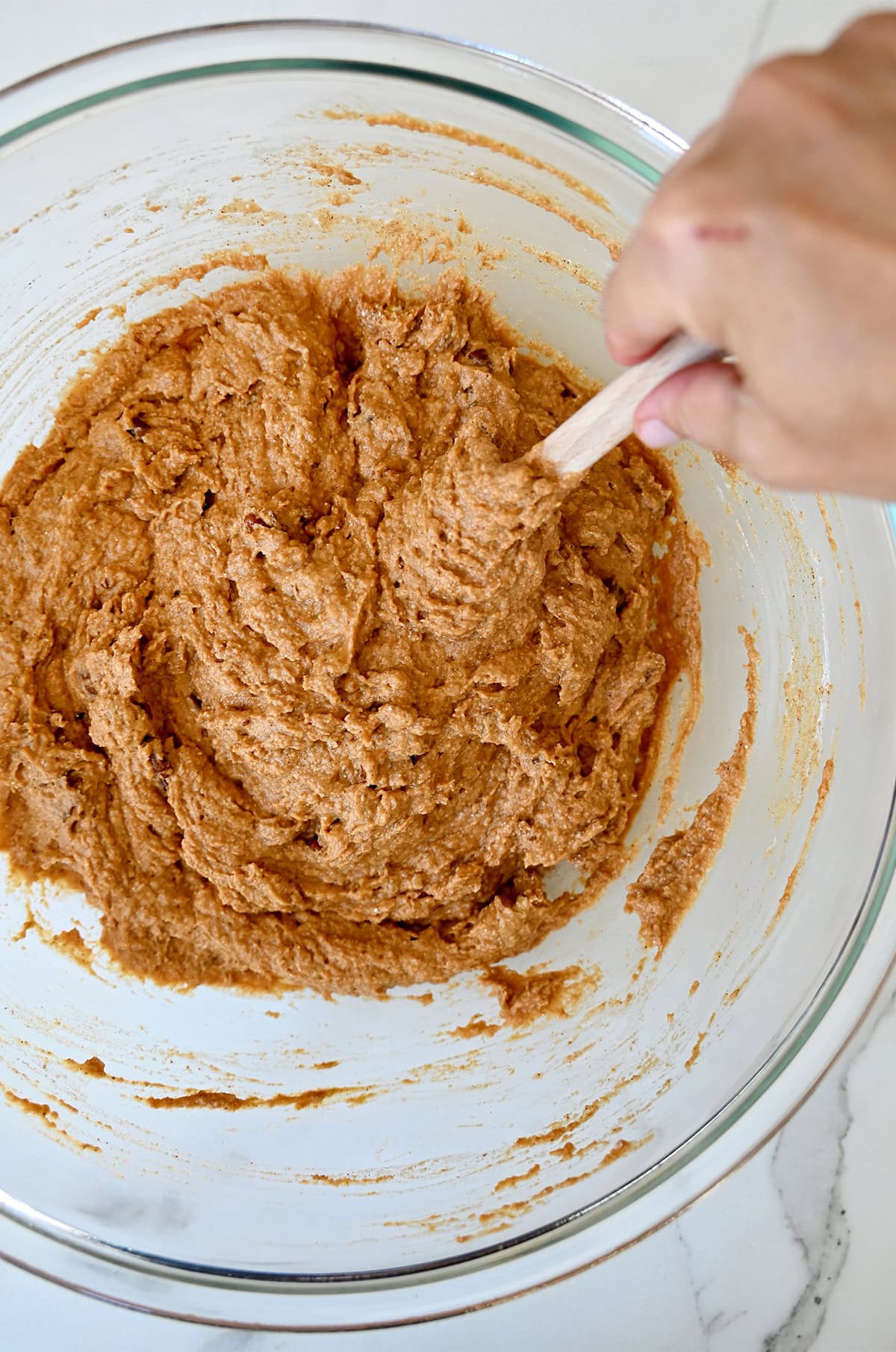 Pumpkin muffin batter in a glass bowl.