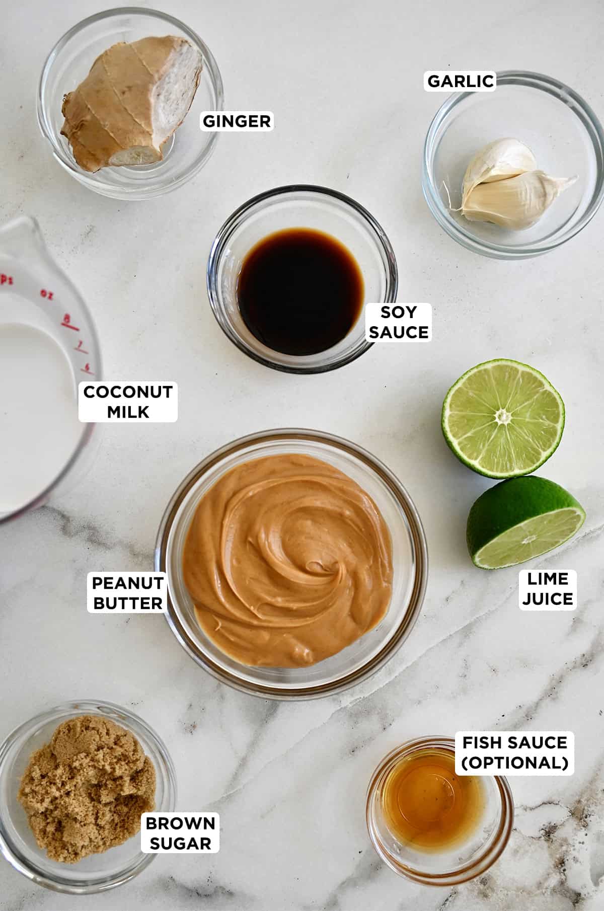 Peanut sauce ingredients, including creamy peanut butter, soy sauce, coconut milk, brown sugar, fish sauce, lime juice, grated ginger and garlic.