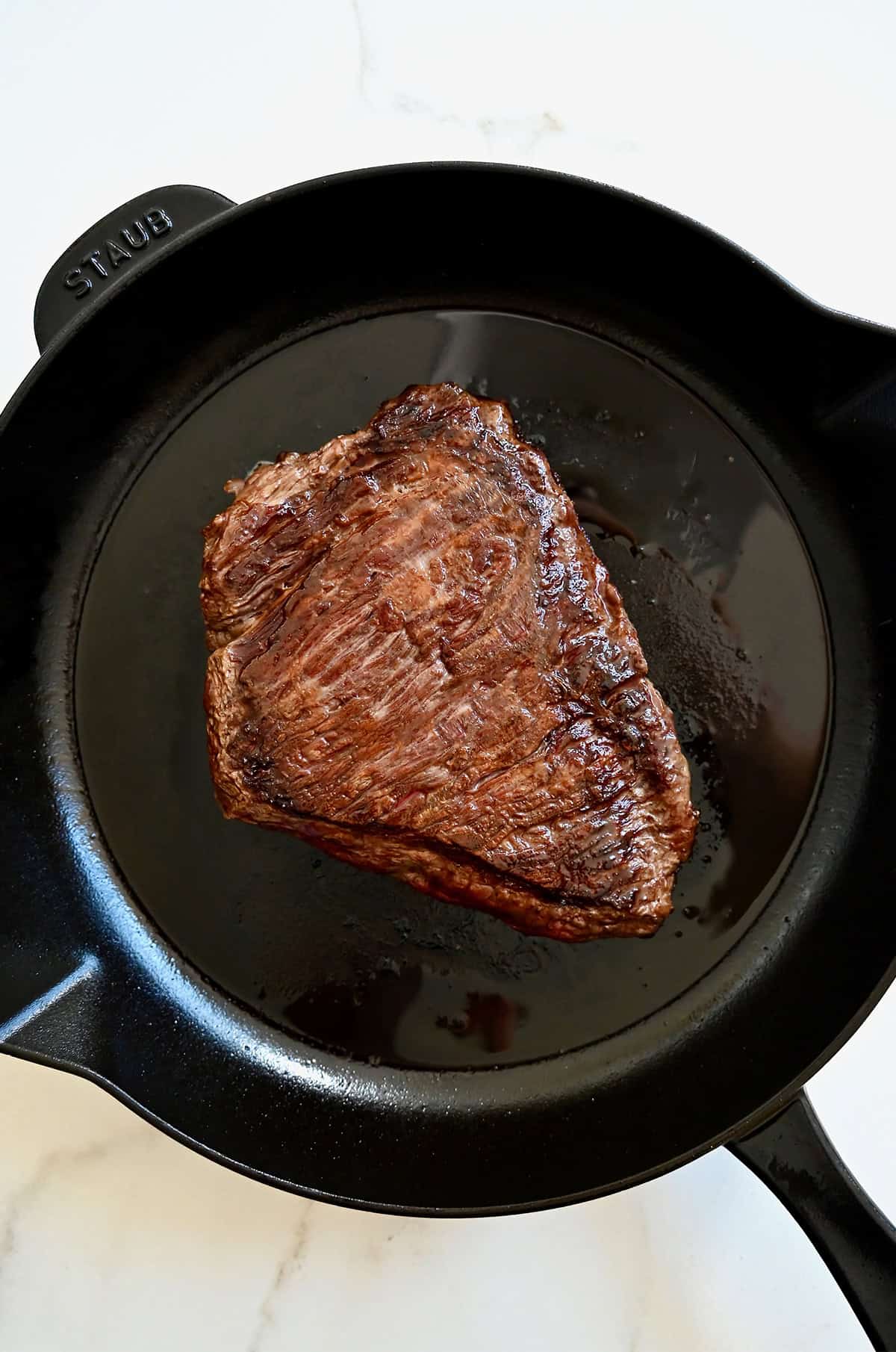 Seared steak in a cast iron pan.