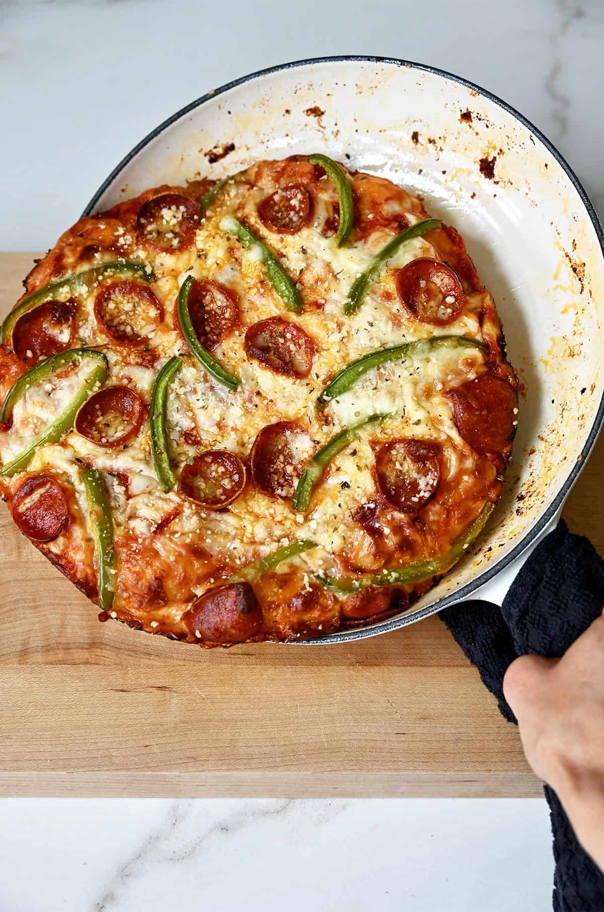 A skillet pizza with a crispy golden brown crust easily slides out of the pan onto a cutting board.
