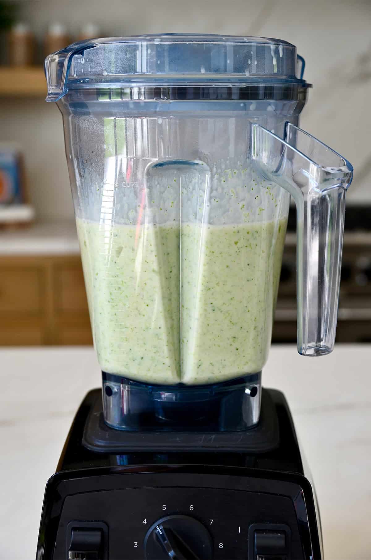 A blender containing creamy cheddar cheese and broccoli soup.