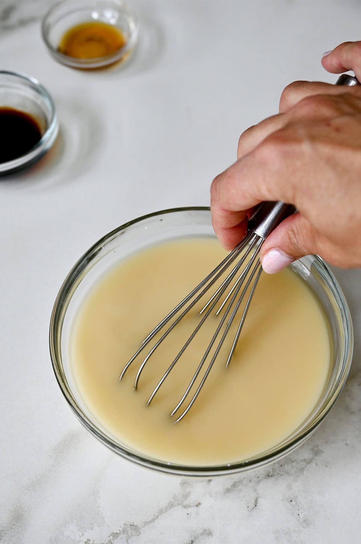 Whisking cornstarch together with chicken stock in a small bowl.