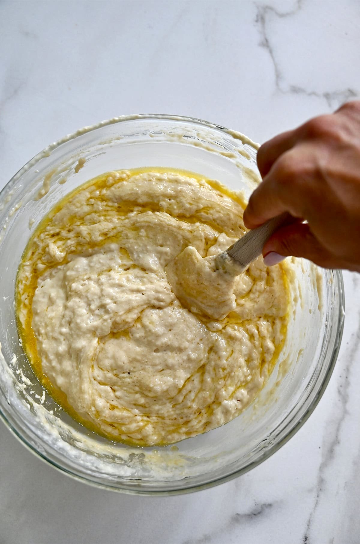 Protein waffle batter in a bowl being stirred together with a spatula.