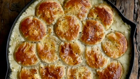 Easy homemade chicken pot pie topped with a puff pastry crust in a cast iron skillet.